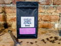 Bag of Fuel Aero Brazil single origin coffee, ground for AeroPress, on a shelf in front of a brick wall with a retro spanner