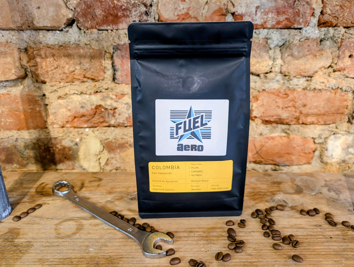 Bag of Fuel Aero Colombia single origin coffee, ground for AeroPress, on a shelf with a retro spanner and coffee beans