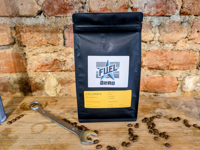 Bag of Fuel Aero Colombia single origin coffee, ground for AeroPress, on a shelf with a retro spanner and coffee beans